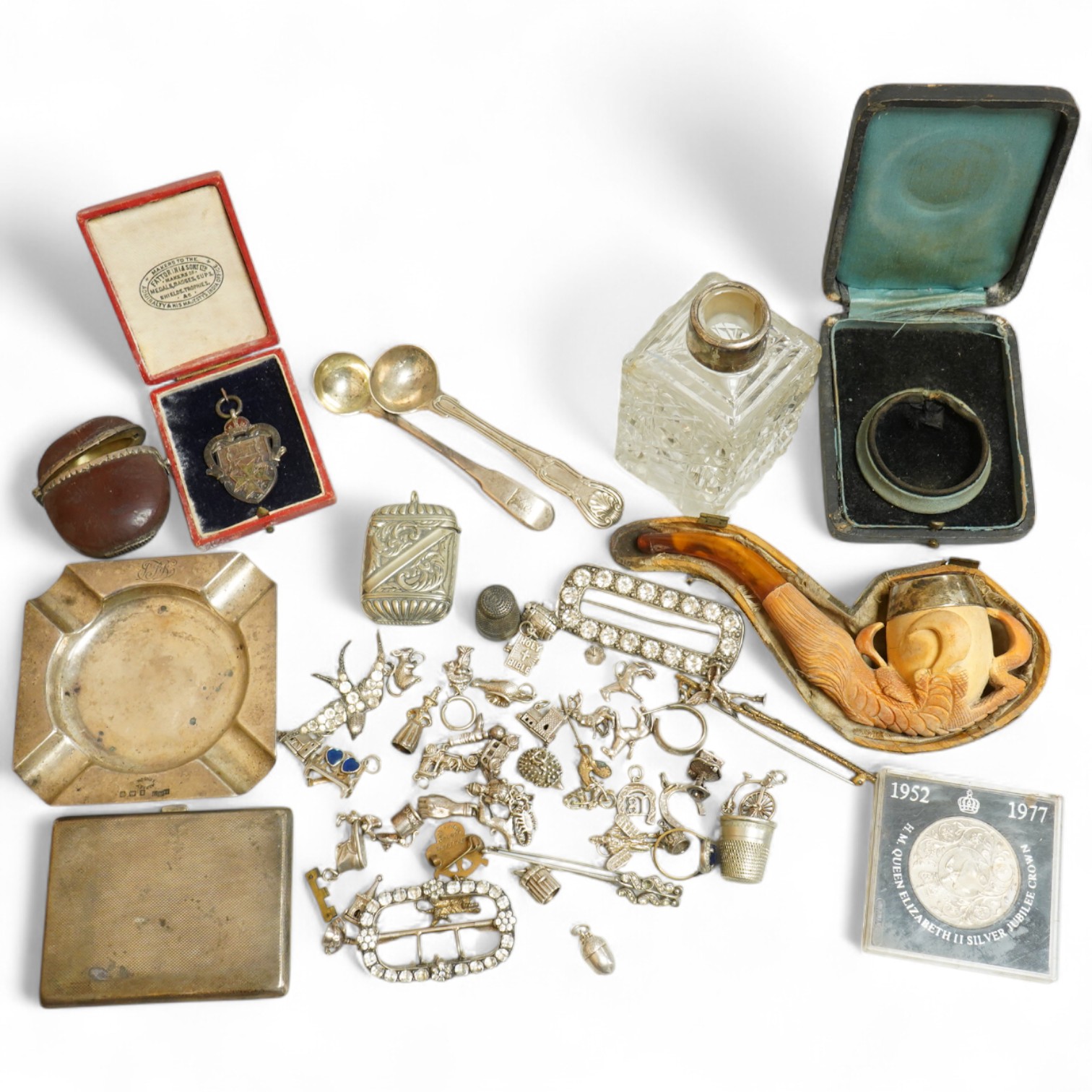 A small collection of silver and white metal charms, including Holy Bible, Penny Farthing, hedgehog and squirrel, together with a silver compact and ashtray, a silver and paste brooch, nut vesta, pipe, etc.